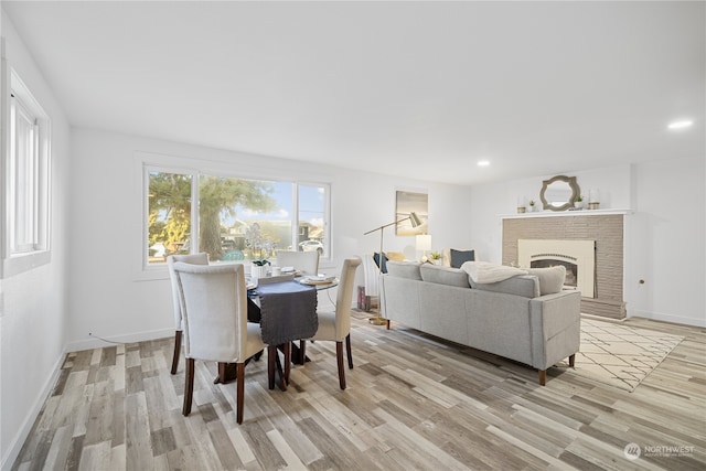 dining space featuring light hardwood / wood-style flooring and a fireplace