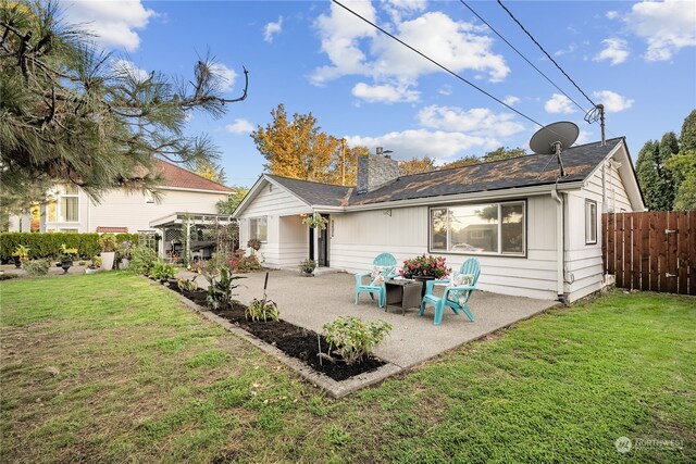 rear view of property featuring a patio and a lawn