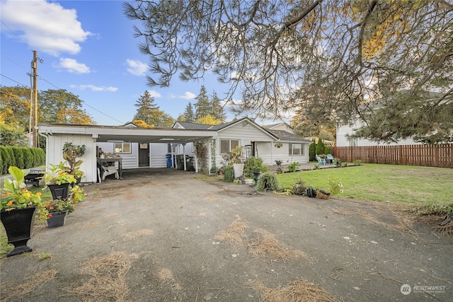 view of front of house featuring a carport and a front lawn