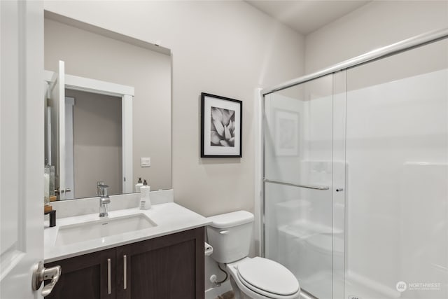 bathroom featuring vanity, an enclosed shower, and toilet