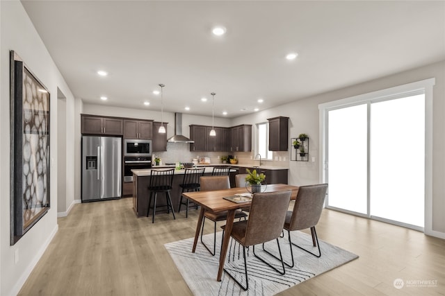 dining area with sink and light hardwood / wood-style floors