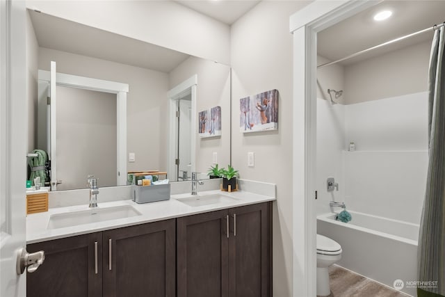 full bathroom with vanity, wood-type flooring, shower / tub combination, and toilet