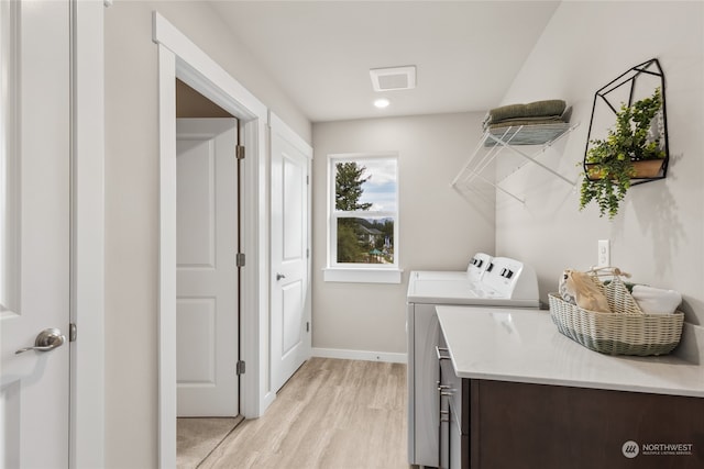 clothes washing area featuring light hardwood / wood-style flooring and independent washer and dryer