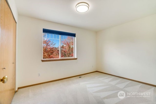 unfurnished bedroom with light colored carpet and a closet