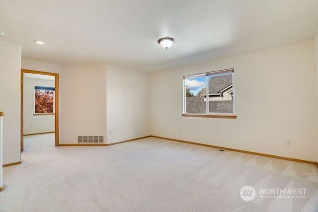 spare room featuring light carpet