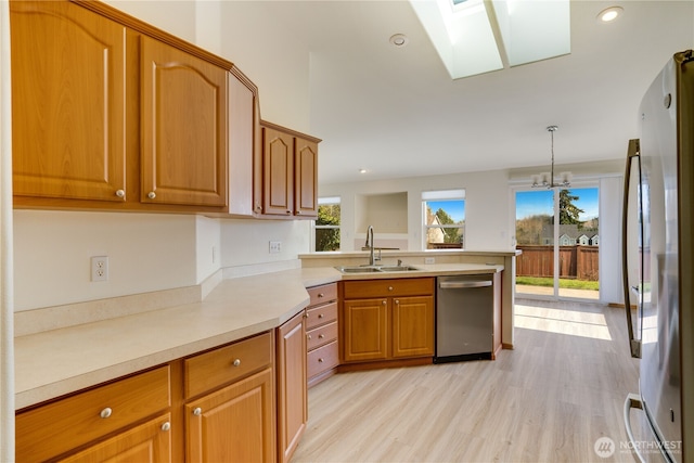 kitchen featuring a sink, appliances with stainless steel finishes, a wealth of natural light, and a skylight