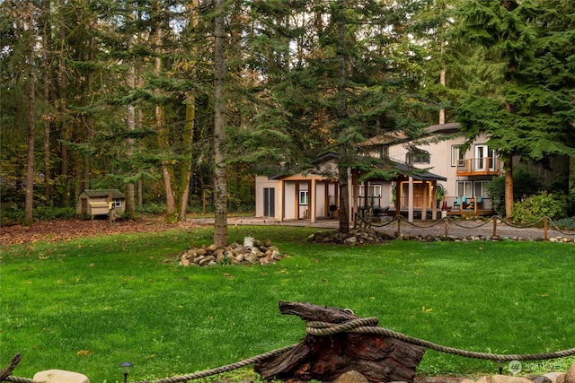 view of yard featuring a storage shed, a balcony, and a patio area