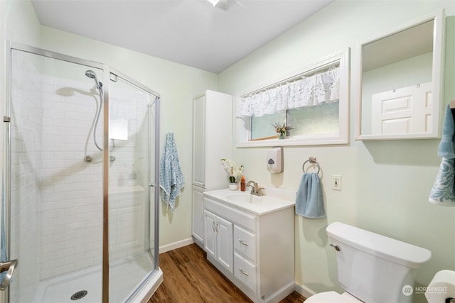 bathroom featuring vanity, toilet, an enclosed shower, and hardwood / wood-style floors