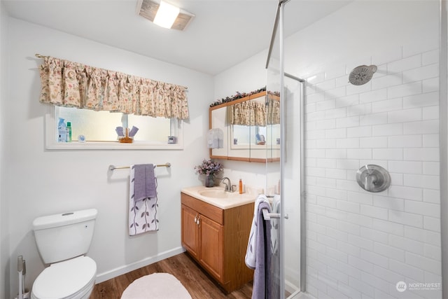 bathroom featuring vanity, toilet, hardwood / wood-style flooring, and walk in shower