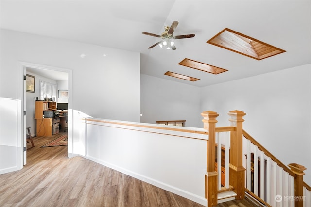 corridor featuring a skylight and light hardwood / wood-style flooring