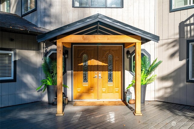 view of exterior entry featuring a wooden deck