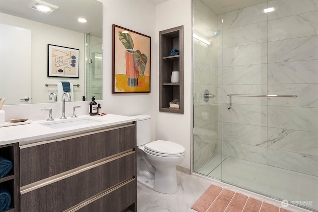 bathroom featuring vanity, toilet, and a shower with shower door