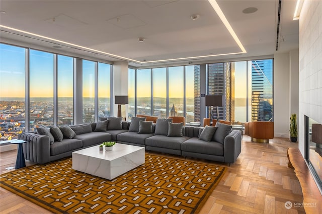 living room featuring parquet flooring, a wall of windows, and a tiled fireplace