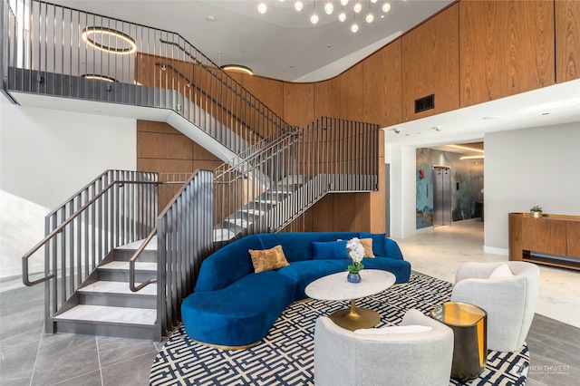 living room featuring a high ceiling and wooden walls