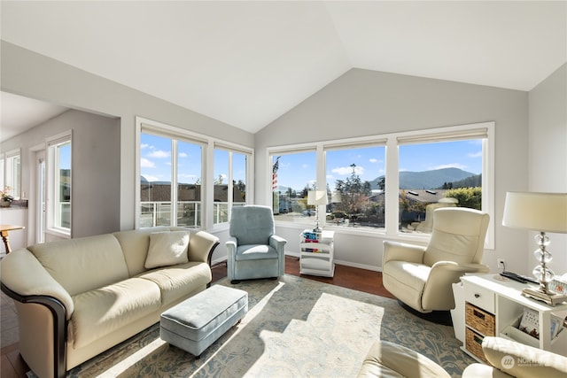 sunroom / solarium featuring a wealth of natural light, lofted ceiling, and a mountain view