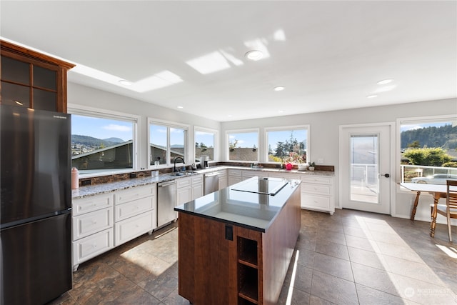 kitchen with sink, a kitchen island, white cabinetry, stainless steel appliances, and a mountain view