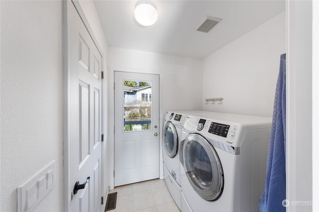 laundry room with washer and dryer and light tile patterned flooring