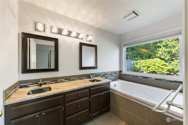 bathroom featuring vanity, tile patterned floors, and tiled bath