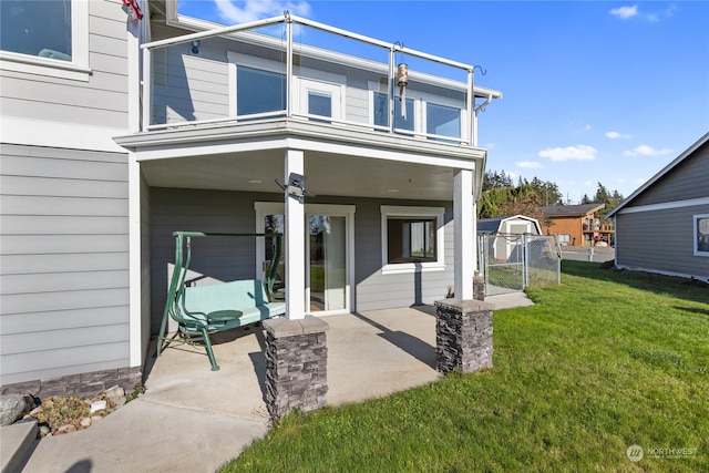 exterior space featuring a balcony, a patio, and a lawn