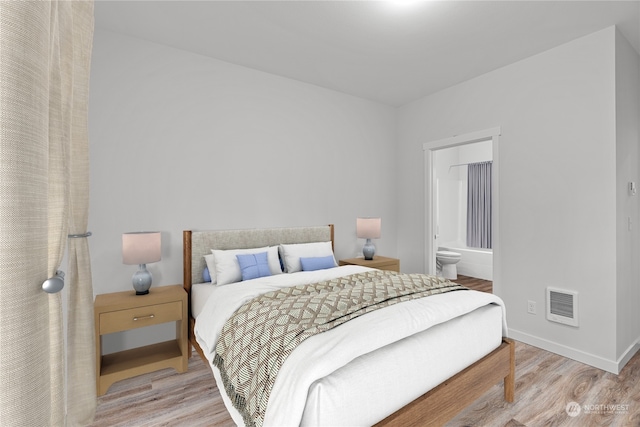 bedroom featuring connected bathroom and light hardwood / wood-style flooring