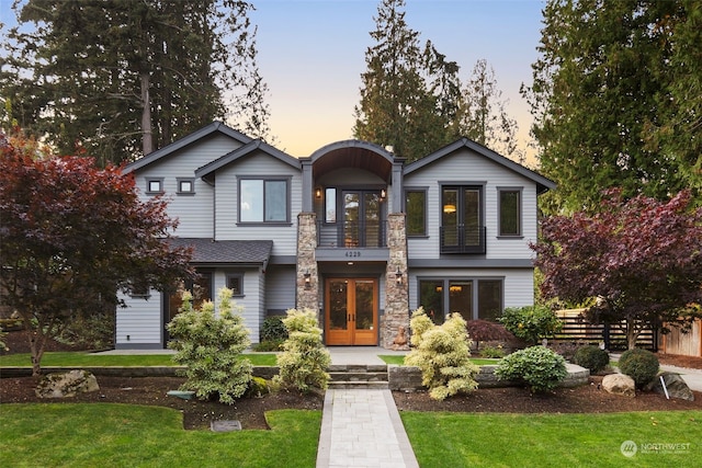 view of front facade with french doors and a yard