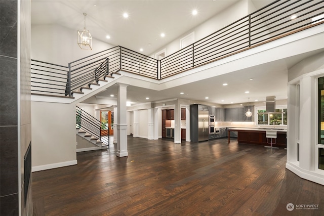 interior space featuring a towering ceiling and dark hardwood / wood-style floors