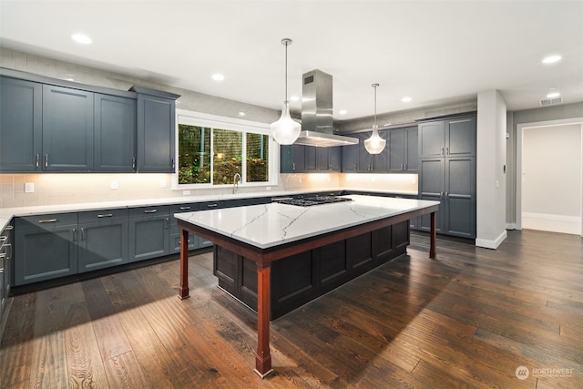 kitchen with island range hood, stainless steel gas stovetop, pendant lighting, and dark hardwood / wood-style floors