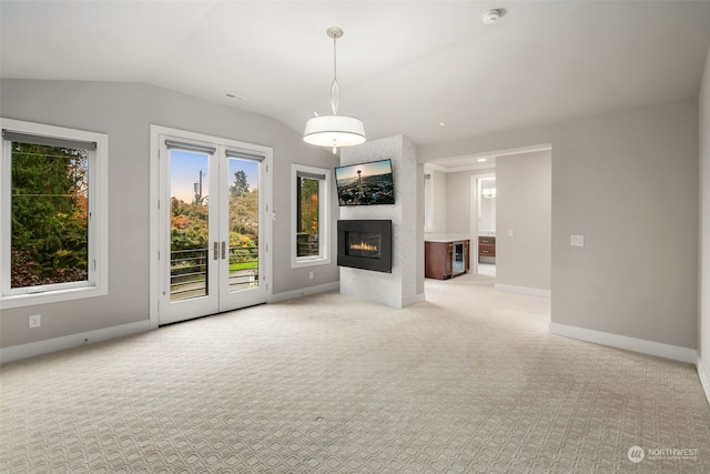 unfurnished living room with lofted ceiling and light colored carpet