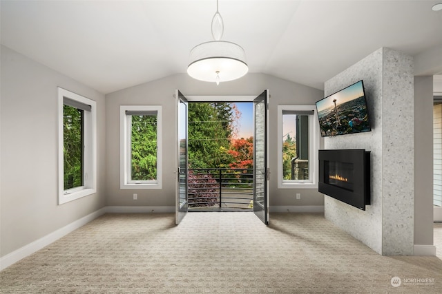 interior space with carpet, vaulted ceiling, and a large fireplace