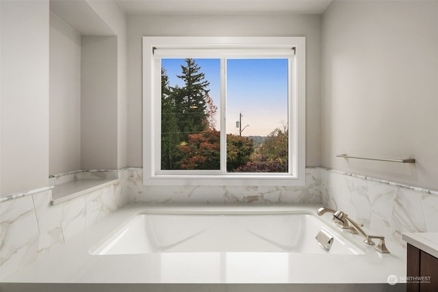 bathroom featuring vanity and a washtub