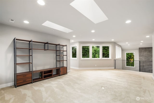 unfurnished living room featuring light carpet and lofted ceiling with skylight