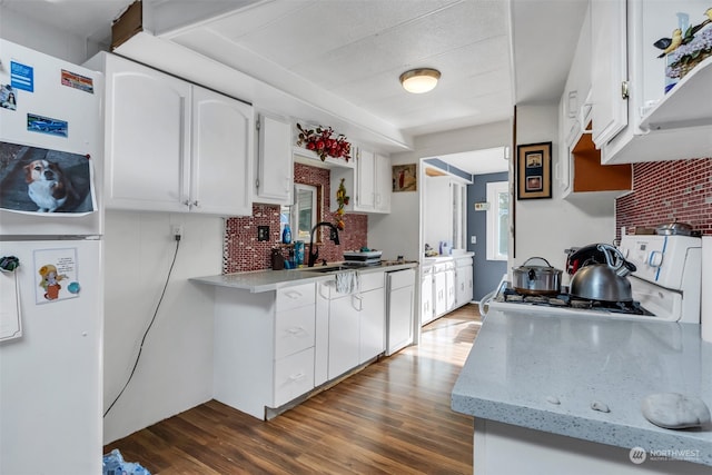 kitchen featuring dark wood-type flooring, white refrigerator, plenty of natural light, and white cabinets