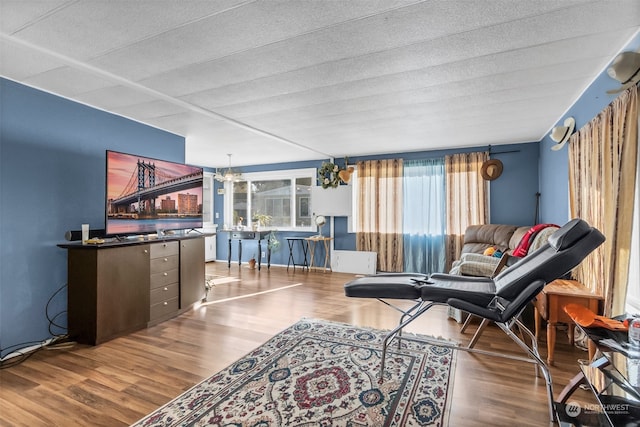 living room featuring a textured ceiling, a notable chandelier, and hardwood / wood-style flooring