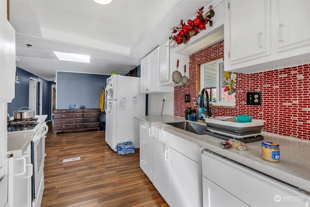 kitchen with decorative backsplash, white cabinetry, dark hardwood / wood-style floors, sink, and white appliances