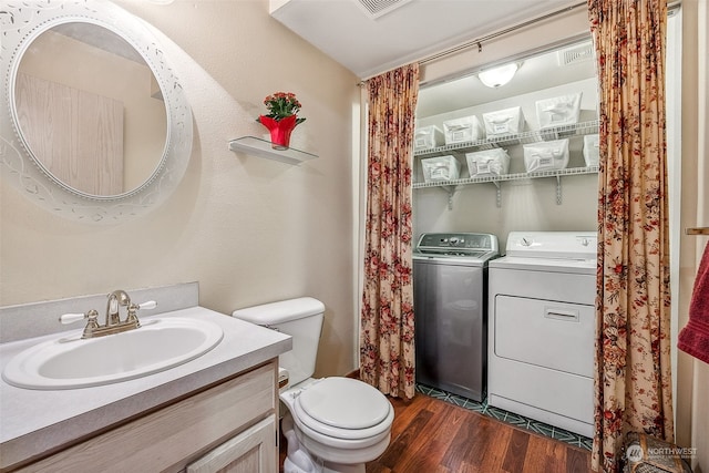 bathroom with vanity, hardwood / wood-style floors, toilet, and washer and dryer