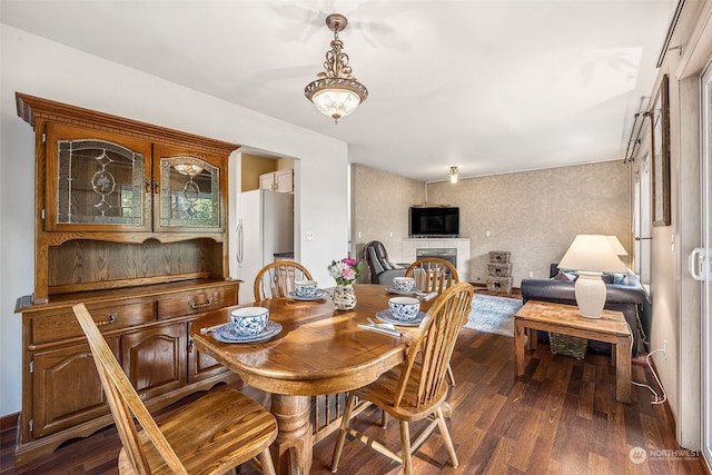 dining room featuring dark hardwood / wood-style flooring and a tile fireplace