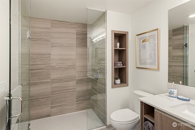 bathroom with vanity, toilet, and an enclosed shower