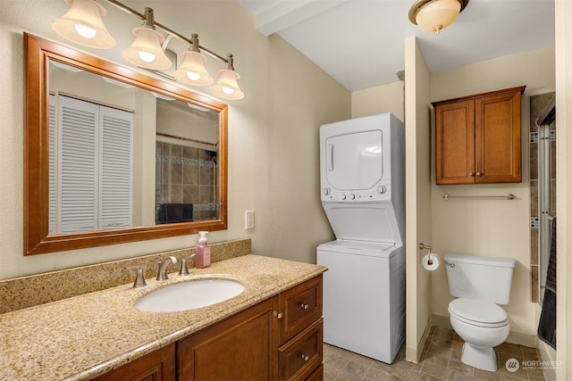 bathroom with vanity, stacked washer / drying machine, lofted ceiling with beams, and toilet