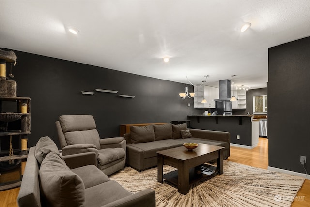 living room with light hardwood / wood-style floors and a notable chandelier