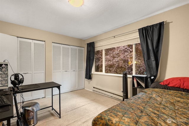 carpeted bedroom featuring a textured ceiling, baseboard heating, and multiple closets