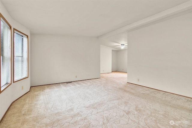 carpeted empty room featuring ceiling fan and a healthy amount of sunlight