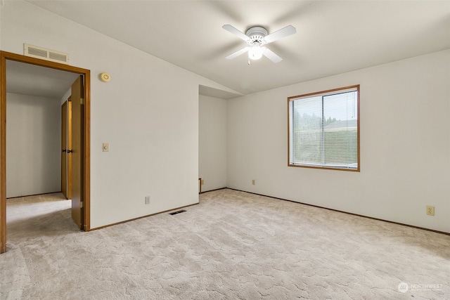 carpeted empty room with ceiling fan and vaulted ceiling