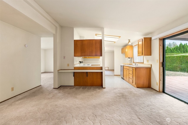 kitchen featuring stainless steel dishwasher, sink, kitchen peninsula, and light carpet