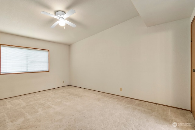 spare room with ceiling fan and light carpet