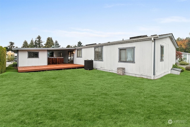 rear view of house with a lawn, a deck, and central air condition unit