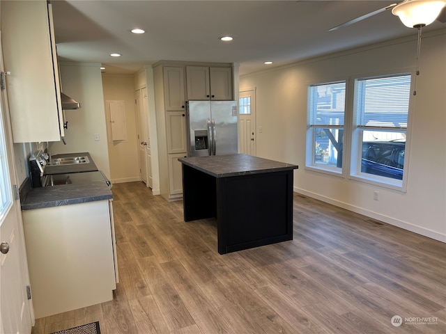 kitchen with range hood, hardwood / wood-style flooring, a kitchen island, and stainless steel fridge with ice dispenser