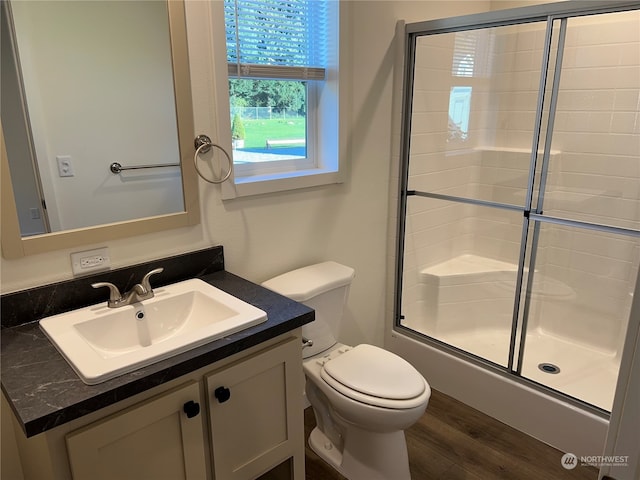 full bathroom featuring toilet, bath / shower combo with glass door, hardwood / wood-style flooring, and vanity