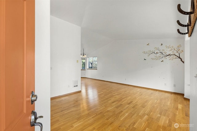 unfurnished living room featuring lofted ceiling and wood-type flooring