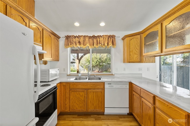 kitchen with sink, light hardwood / wood-style floors, and white appliances