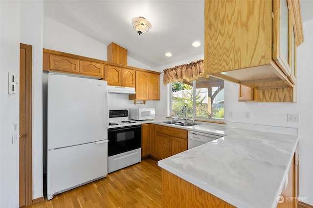 kitchen featuring sink, vaulted ceiling, kitchen peninsula, and white appliances